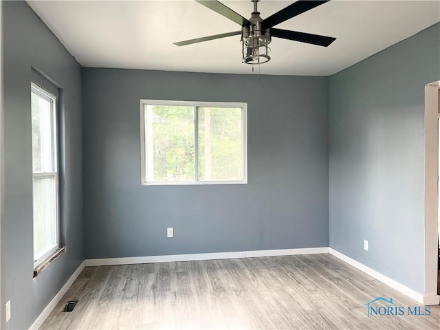 3927 Vermaas Ave, Toledo, OH 43612 - empty room with ceiling fan, wood finished floors, and healthy amount of natural light