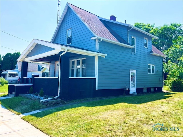 3927 Vermaas Ave, Toledo, OH 43612 - view of side of property with a yard, covered porch, a chimney, and roof with shingles