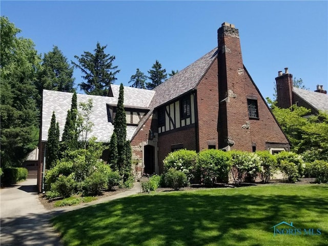 3704 Brookside Rd, Ottawa Hills, OH 43606 - view of front of house featuring a front lawn, a chimney, and brick siding