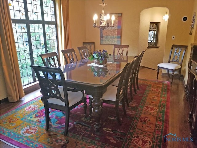 3704 Brookside Rd, Ottawa Hills, OH 43606 - dining space featuring wood finished floors, a chandelier, a textured wall, and arched walkways