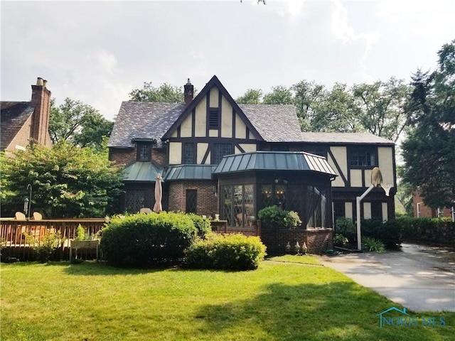 3704 Brookside Rd, Ottawa Hills, OH 43606 - back of property with a standing seam roof, a lawn, a metal roof, and brick siding