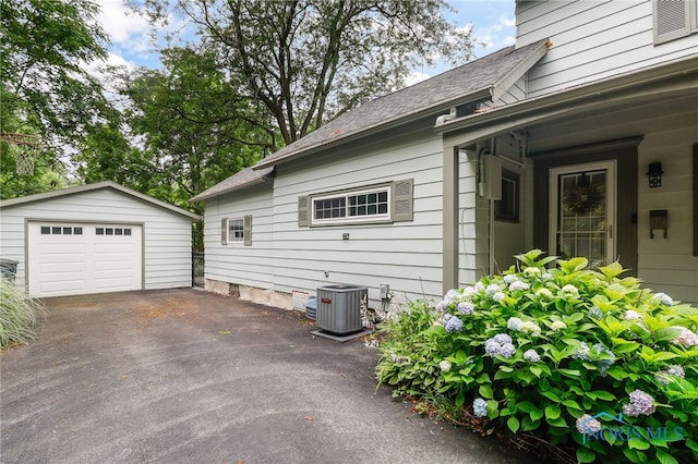 545 Wallace Ave, Bowling Green, OH 43402 - view of side of property featuring an outbuilding, a detached garage, driveway, and a shingled roof