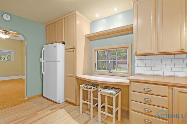545 Wallace Ave, Bowling Green, OH 43402 - kitchen featuring freestanding refrigerator, light wood finished floors, tasteful backsplash, arched walkways, and a ceiling fan
