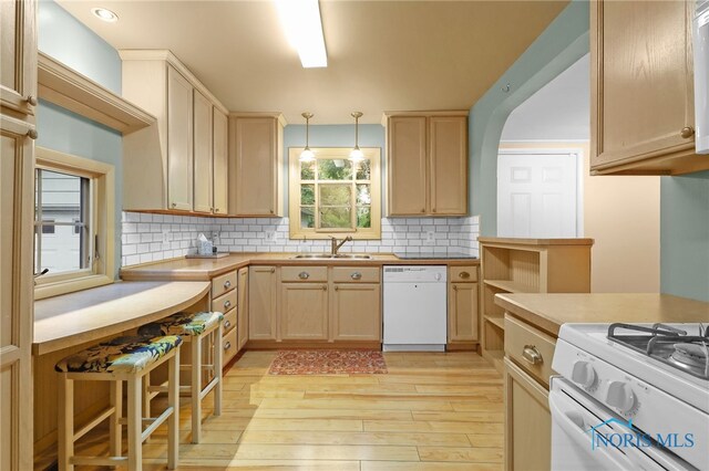545 Wallace Ave, Bowling Green, OH 43402 - kitchen featuring white appliances, light wood-style floors, decorative backsplash, hanging light fixtures, and light brown cabinetry