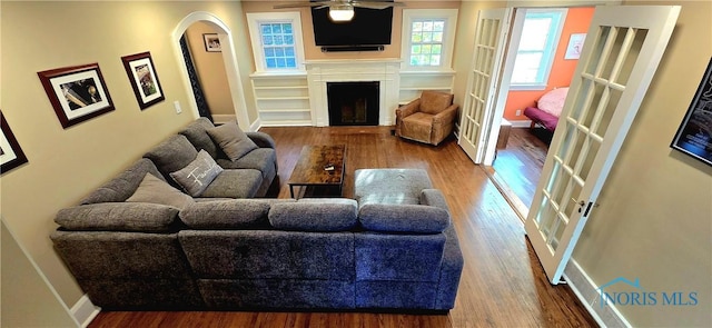3329 Kirkwall Rd, Ottawa Hills, OH 43606 - living area with wood finished floors, a fireplace, arched walkways, and a ceiling fan