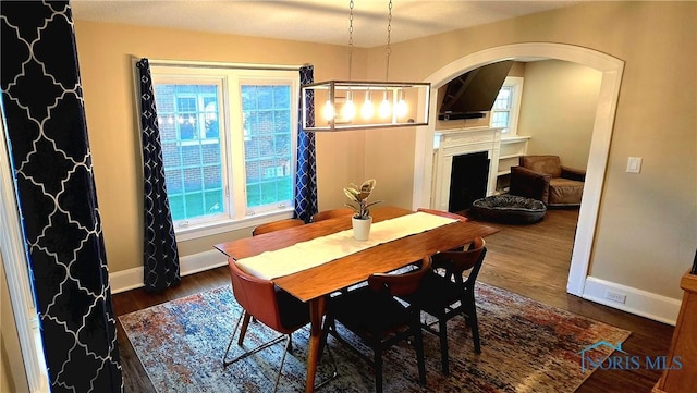 3329 Kirkwall Rd, Ottawa Hills, OH 43606 - dining area featuring arched walkways, wood finished floors, plenty of natural light, and a fireplace