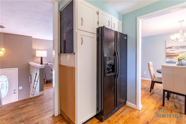6768 Denbridge Dr, Sylvania, OH 43560 - kitchen with black refrigerator with ice dispenser, a chandelier, white cabinetry, light wood-style floors, and decorative light fixtures