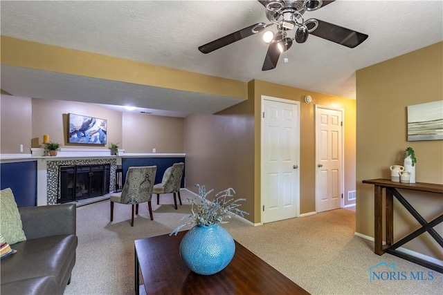 6768 Denbridge Dr, Sylvania, OH 43560 - living area featuring carpet flooring, a ceiling fan, and a tiled fireplace