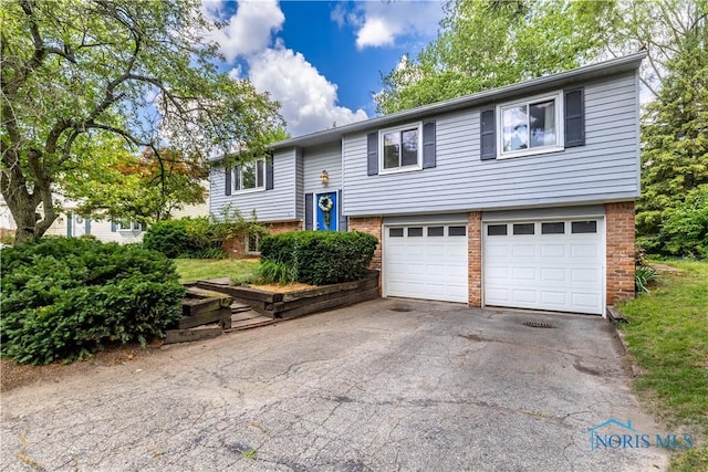 6768 Denbridge Dr, Sylvania, OH 43560 - bi-level home with a garage, driveway, and brick siding