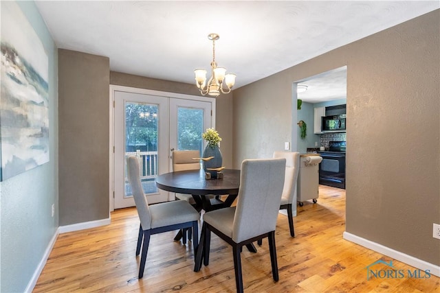6768 Denbridge Dr, Sylvania, OH 43560 - dining space featuring a chandelier, light wood finished floors, a textured wall, and french doors