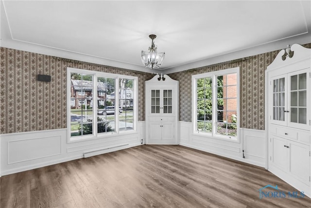 2310 Goddard Rd, Toledo, OH 43606 - unfurnished dining area featuring a chandelier, wallpapered walls, wainscoting, plenty of natural light, and wood finished floors