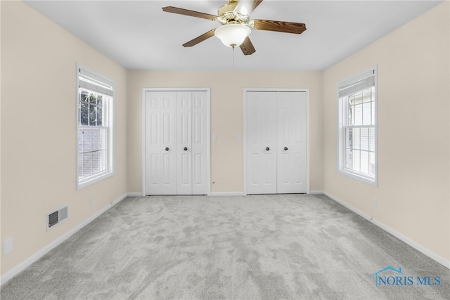 2310 Goddard Rd, Toledo, OH 43606 - unfurnished bedroom featuring two closets, carpet floors, and a ceiling fan