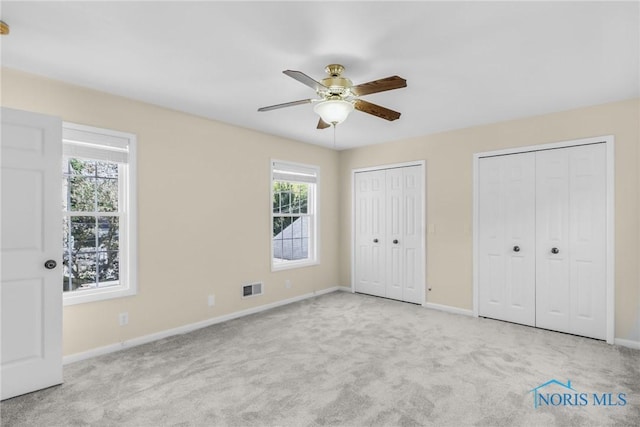 2310 Goddard Rd, Toledo, OH 43606 - unfurnished bedroom with carpet floors, two closets, and a ceiling fan