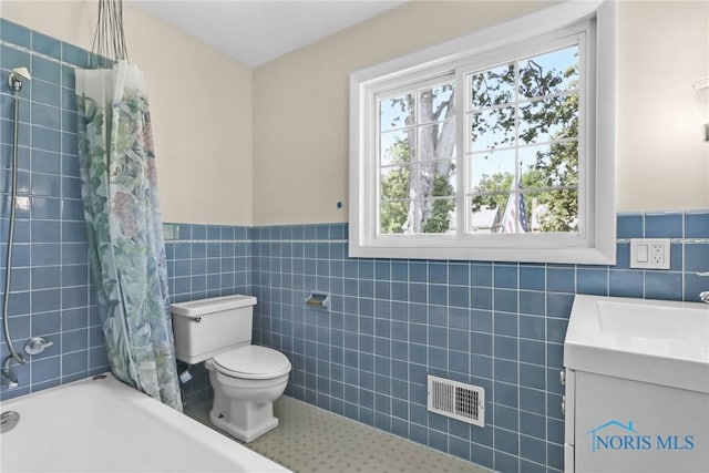 2310 Goddard Rd, Toledo, OH 43606 - full bathroom featuring tile walls, vanity, healthy amount of natural light, shower / bathtub combination with curtain, and wainscoting
