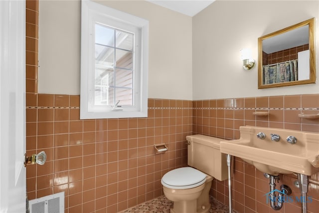 2310 Goddard Rd, Toledo, OH 43606 - full bath featuring healthy amount of natural light, tile walls, wainscoting, and tile patterned flooring