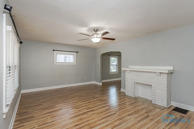 4334 Commonwealth Ave, Toledo, OH 43612 - unfurnished living room with arched walkways, healthy amount of natural light, ceiling fan, and light wood-style flooring