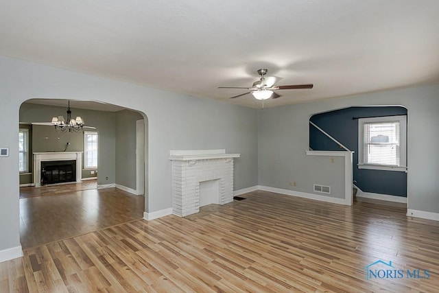4334 Commonwealth Ave, Toledo, OH 43612 - unfurnished living room with a fireplace, a ceiling fan, wood finished floors, and a chandelier