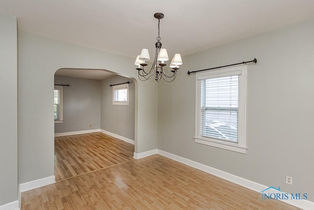 4334 Commonwealth Ave, Toledo, OH 43612 - unfurnished room featuring arched walkways, light wood-style floors, and a chandelier