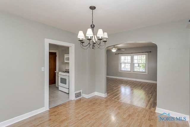 4334 Commonwealth Ave, Toledo, OH 43612 - spare room featuring arched walkways, a chandelier, light wood-style flooring, and a ceiling fan