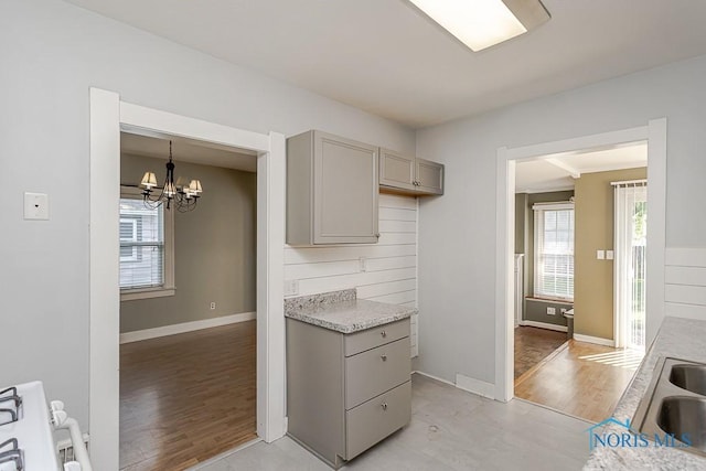 4334 Commonwealth Ave, Toledo, OH 43612 - kitchen with gray cabinets, a chandelier, light wood-style floors, and range
