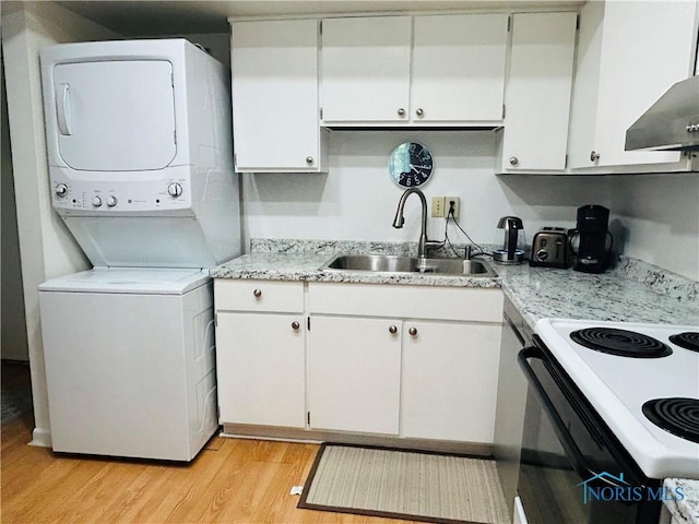4243 W Bancroft St Unit 202W, Ottawa Hills, OH 43615 - kitchen featuring stacked washer / dryer, electric range oven, light countertops, light wood finished floors, and range hood