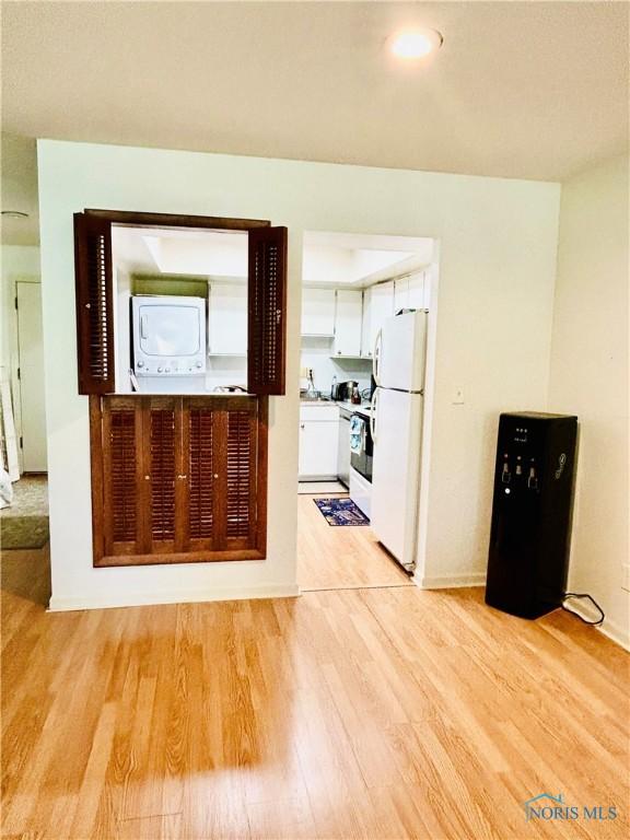 4243 W Bancroft St Unit 202W, Ottawa Hills, OH 43615 - unfurnished living room with light wood finished floors and estacked washer and dryer