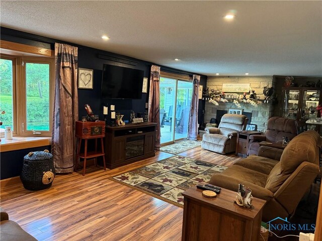 26654 Elliott Rd, Defiance, OH 43512 - living area featuring wood finished floors, a fireplace, recessed lighting, and a textured ceiling