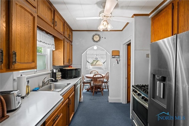 4526 Commonwealth Ave, Toledo, OH 43612 - kitchen with stainless steel appliances, light countertops, brown cabinets, dark carpet, and ornamental molding