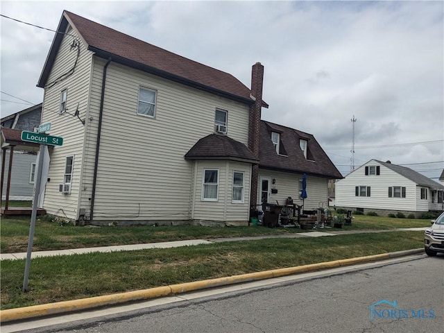 383 E 2nd St, Ottawa, OH 45875 - view of home's exterior featuring a chimney and a yard