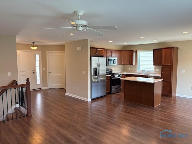 813 Meadowchase Ln, Toledo, OH 43615 - kitchen with stainless steel appliances, a center island, dark wood finished floors, light countertops, and a ceiling fan