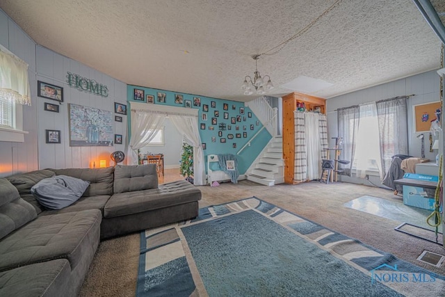 138 Boone Ave, Marion, OH 43302 - living room featuring a chandelier, carpet, stairs, a textured ceiling, and wood walls