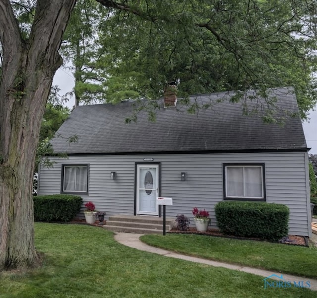 5533 Sunnyside Dr, Toledo, OH 43612 - cape cod home with entry steps, roof with shingles, a front yard, and a chimney