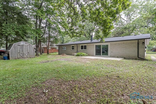 2617 Schroeder St, Toledo, OH 43613 - back of house with a storage shed, a patio area, a yard, and brick siding