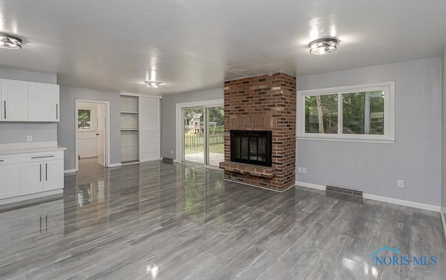 2617 Schroeder St, Toledo, OH 43613 - unfurnished living room featuring wood finished floors, a brick fireplace, and built in features