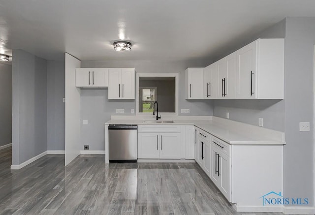 2617 Schroeder St, Toledo, OH 43613 - kitchen featuring stainless steel dishwasher, light countertops, white cabinets, and light wood finished floors