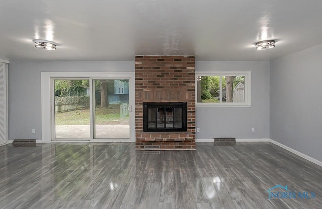 2617 Schroeder St, Toledo, OH 43613 - unfurnished living room featuring healthy amount of natural light, wood finished floors, and a brick fireplace