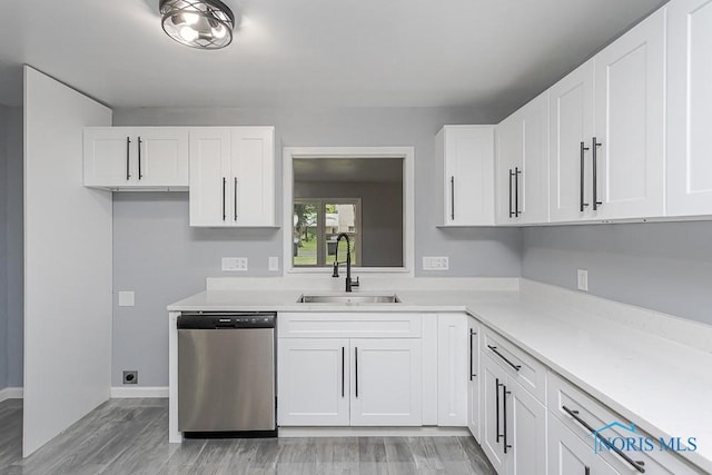 2617 Schroeder St, Toledo, OH 43613 - kitchen featuring stainless steel dishwasher, white cabinets, light wood-style floors, and light countertops