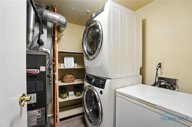 5679 Monroe St Unit 410, Sylvania, OH 43560 - washroom with stacked washer / dryer, wood finished floors, and heating unit