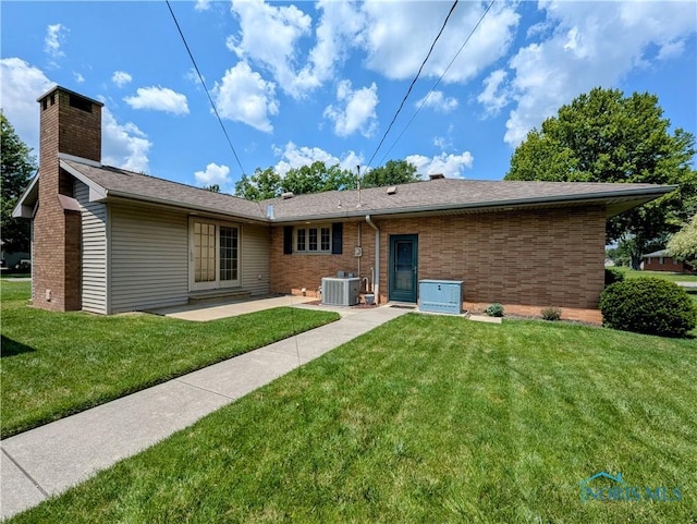 309 Buckeye St, Archbold, OH 43502 - back of house featuring a yard, brick siding, a patio area, and a chimney