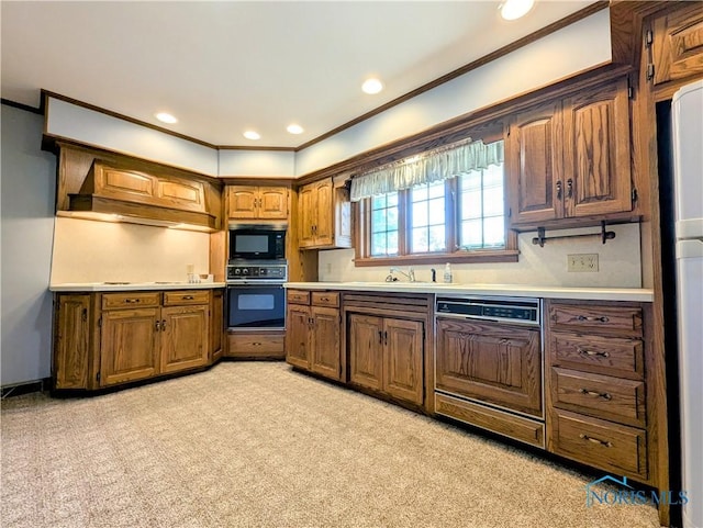 309 Buckeye St, Archbold, OH 43502 - kitchen featuring black appliances, light countertops, crown molding, light colored carpet, and brown cabinets