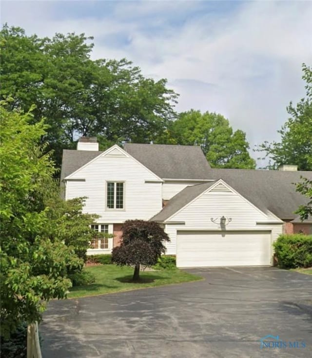 29249 Bates Rd, Perrysburg, OH 43551 - view of front of property with asphalt driveway, a chimney, and an attached garage