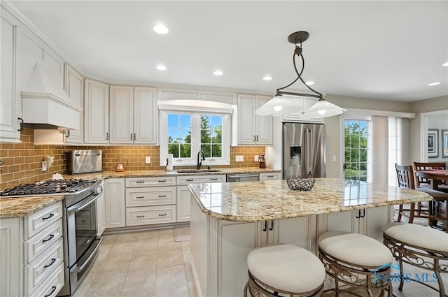 5576 N Citation Rd, Ottawa Hills, OH 43615 - kitchen featuring stainless steel appliances, a kitchen bar, decorative backsplash, plenty of natural light, and recessed lighting
