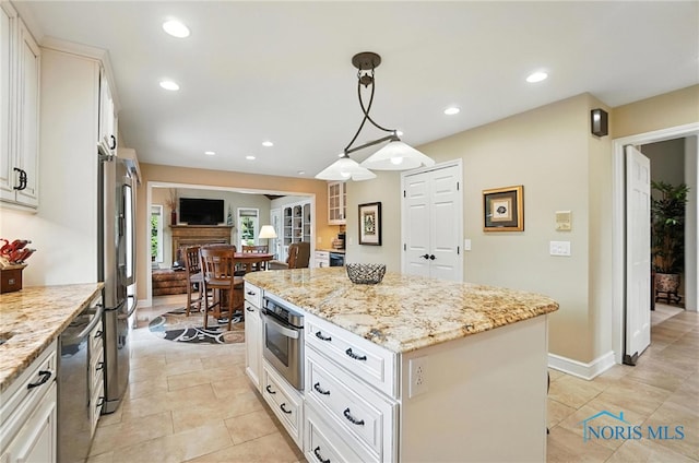 5576 N Citation Rd, Ottawa Hills, OH 43615 - kitchen with appliances with stainless steel finishes, a center island, light stone counters, recessed lighting, and hanging light fixtures