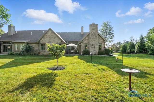 5576 N Citation Rd, Ottawa Hills, OH 43615 - rear view of property featuring a chimney, a lawn, and stone siding