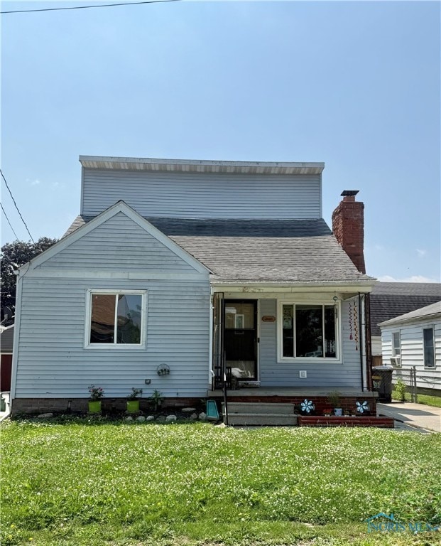 3440 148th St, Toledo, OH 43611 - view of front facade featuring covered porch, a front lawn, and a chimney