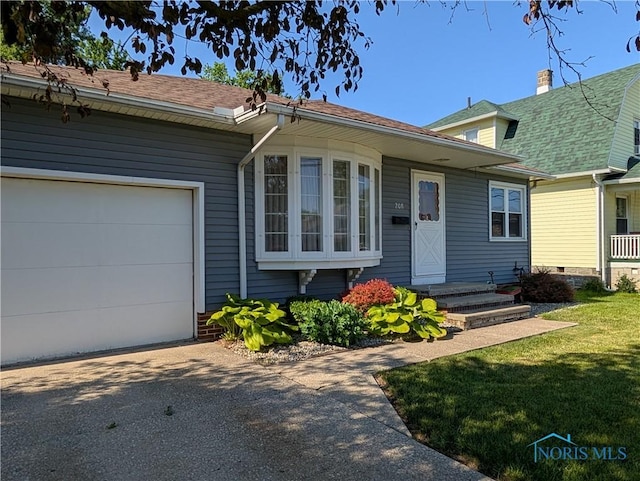 208 E Union St, Walbridge, OH 43465 - view of front of home with a garage, asphalt driveway, and a front lawn
