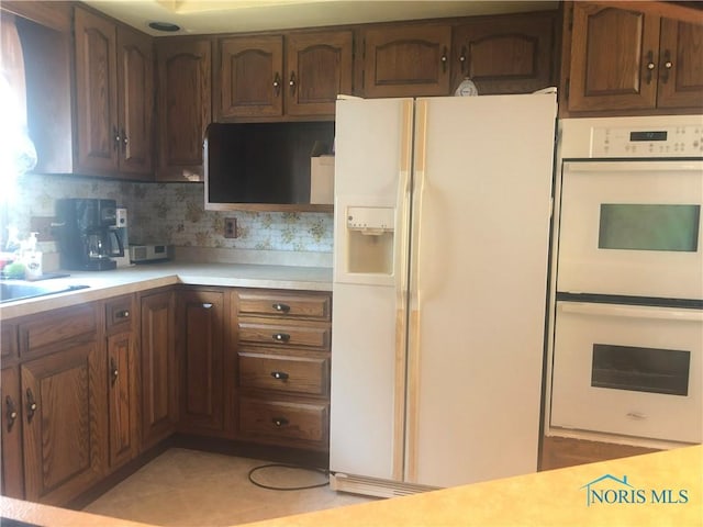 4815 298th St, Toledo, OH 43611 - kitchen with white appliances, light countertops, and backsplash