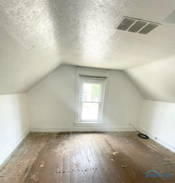 522 Oswald St, Toledo, OH 43605 - bonus room with hardwood / wood-style floors, lofted ceiling, and a textured ceiling
