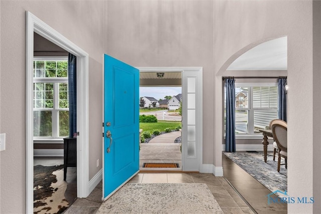 9258 Nate Ct, Sylvania, OH 43560 - foyer with arched walkways, plenty of natural light, a towering ceiling, and tile patterned floors