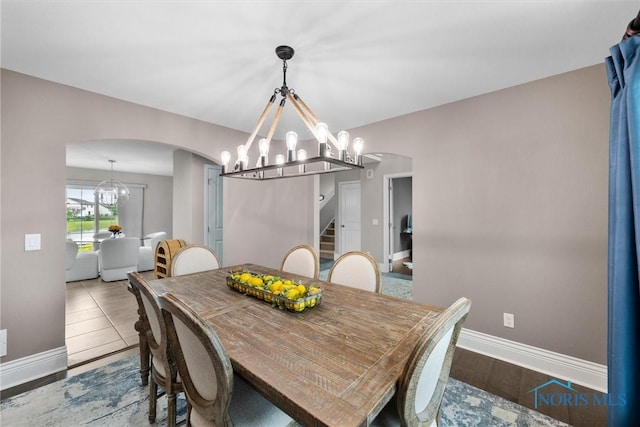 9258 Nate Ct, Sylvania, OH 43560 - dining space with a chandelier, arched walkways, and stairs